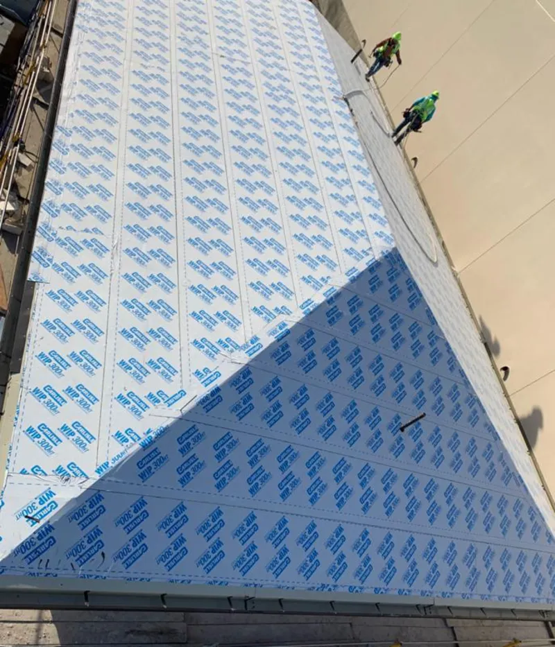 Professional roofers installing underlayment on a metal roof in Bon Air